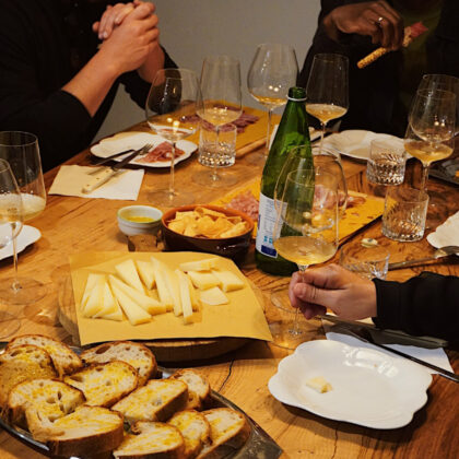 Tavolo imbandito con calici di vino e stuzzichini durante una degustazione presso Extra Wine Shop a Verona